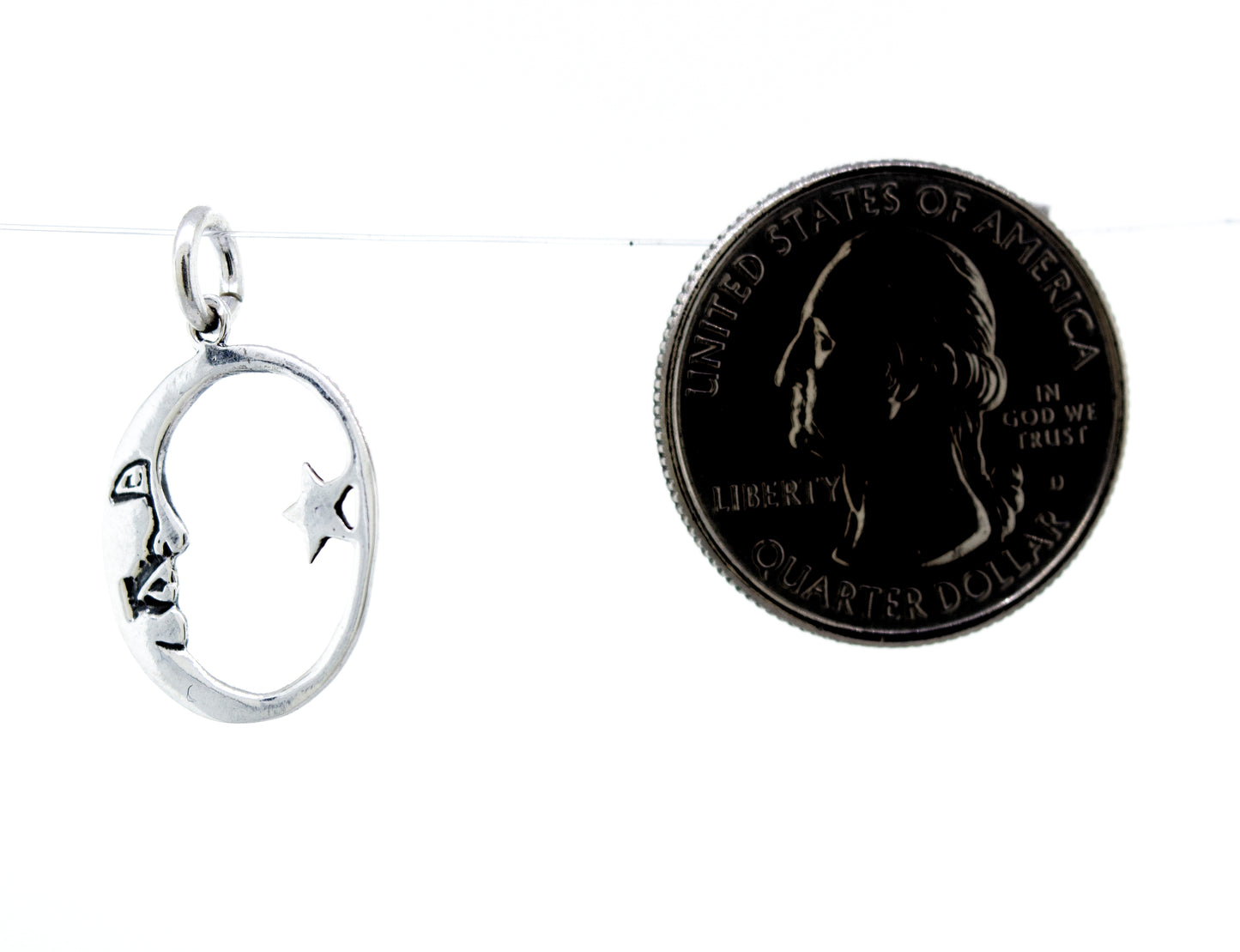 
                  
                    A Super Silver Crescent and Star Pendant featuring a silver charm with a face on it, accompanied by a dime.
                  
                