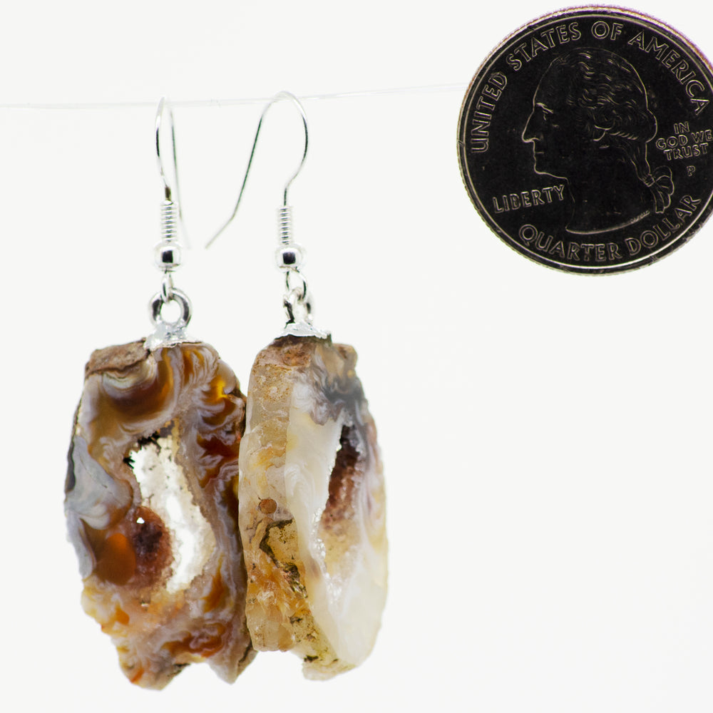 
                  
                    A stunning pair of Agate Geode Slice Earrings featuring a quarter-shaped center cutout, adorned with Agate Geode slices and dangling from elegant Silver-plated hooks.
                  
                