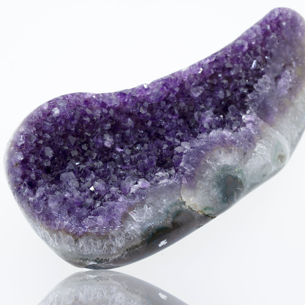 
                  
                    An Oval Shaped Amethyst Geode on a white surface.
                  
                