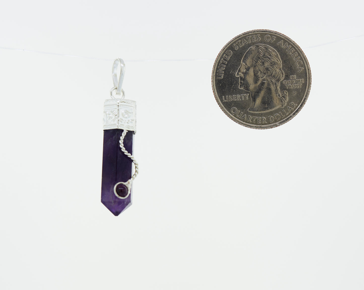 
                  
                    An Amethyst Pendant with Decorated Bail and Small Garnet Stone hanging from a Super Silver chain, perfect for everyday wear.
                  
                
