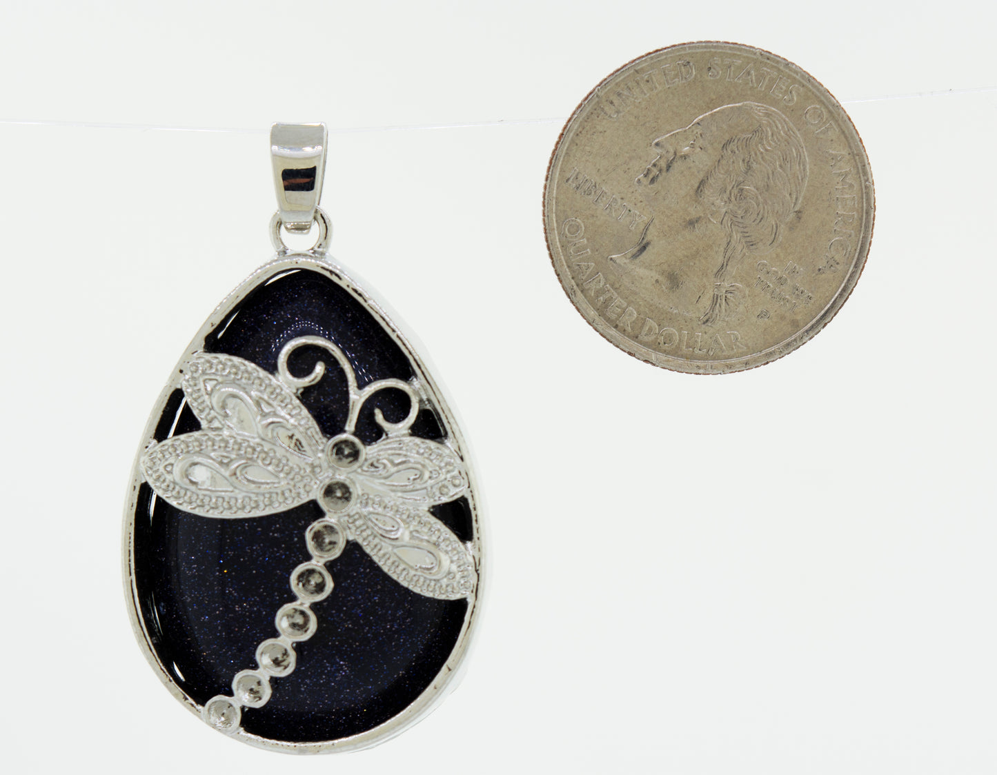 A Super Silver teardrop stone pendant with a dragonfly shape.