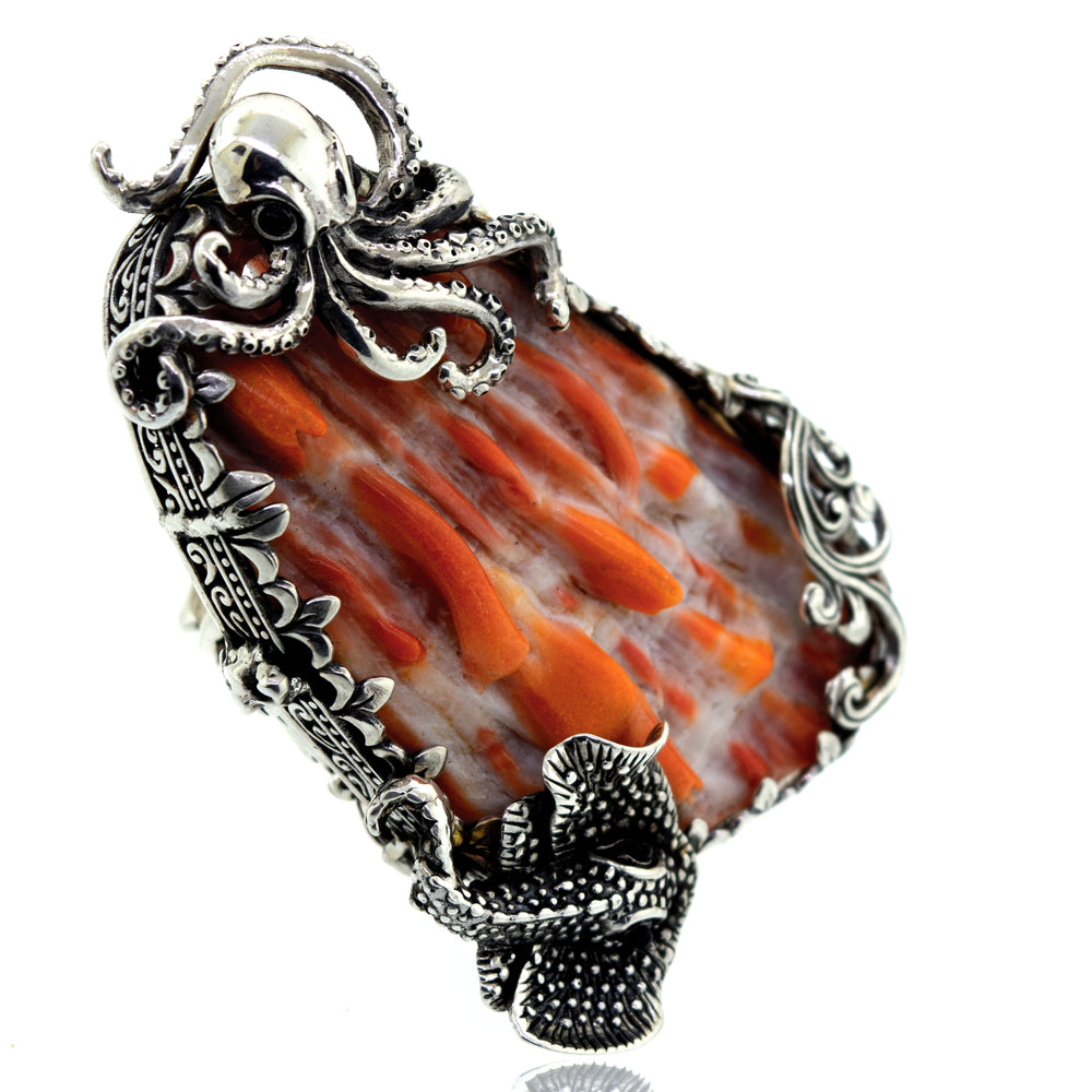 
                  
                    A handcrafted silver octopus pendant with an orange spiny oyster shell stone.
                  
                