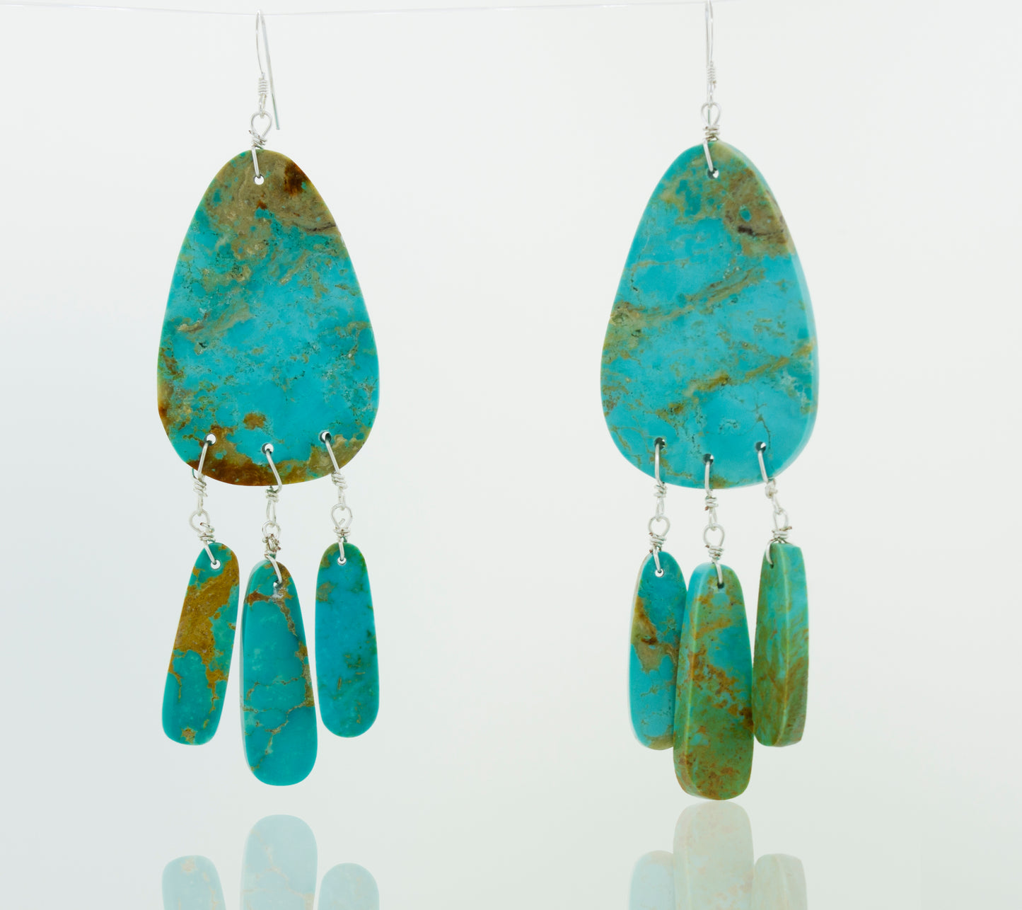 
                  
                    A pair of Super Silver Native American Raw Turquoise Earrings on a white background.
                  
                