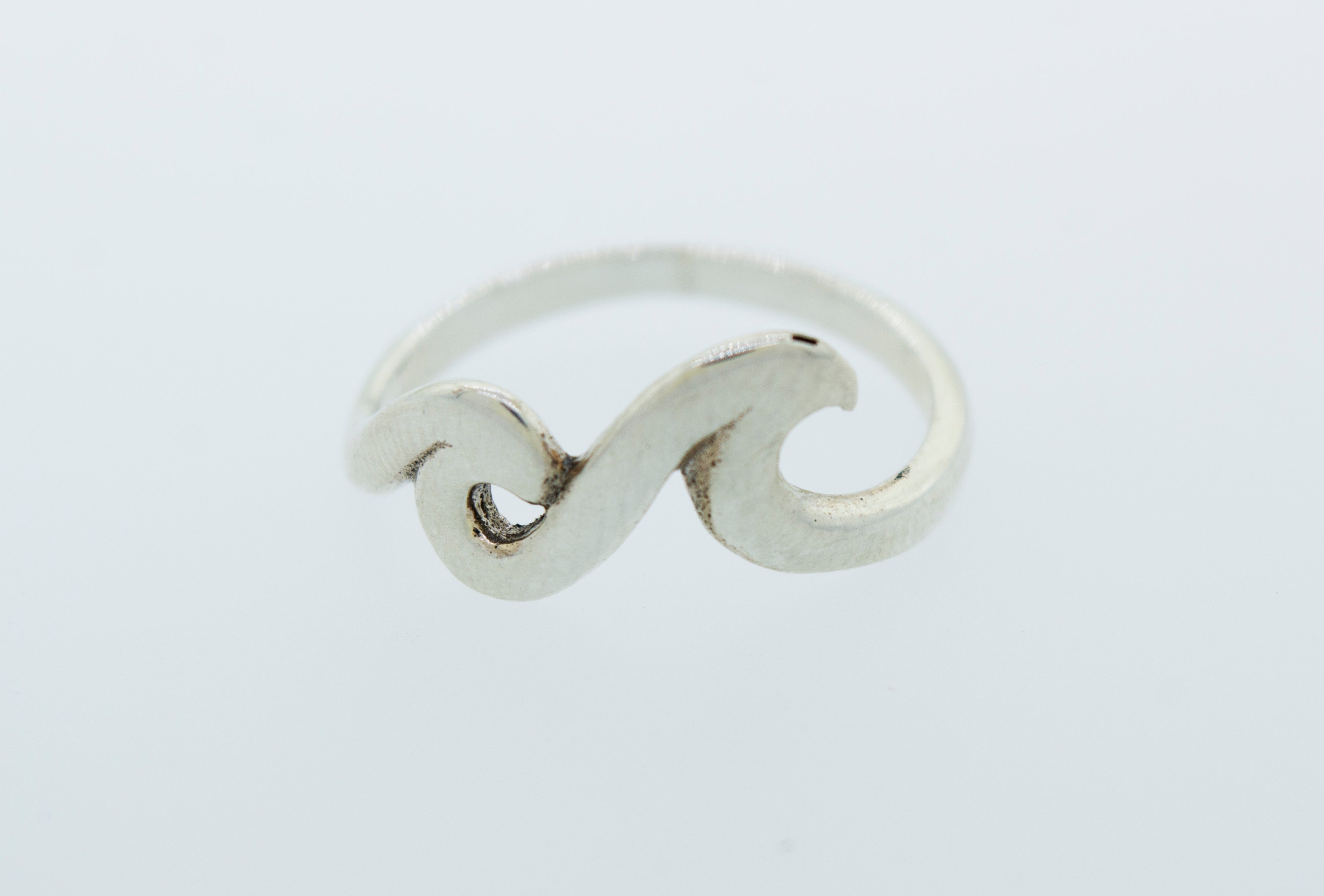 A sterling silver Two Waves Ring with a wave design on it.