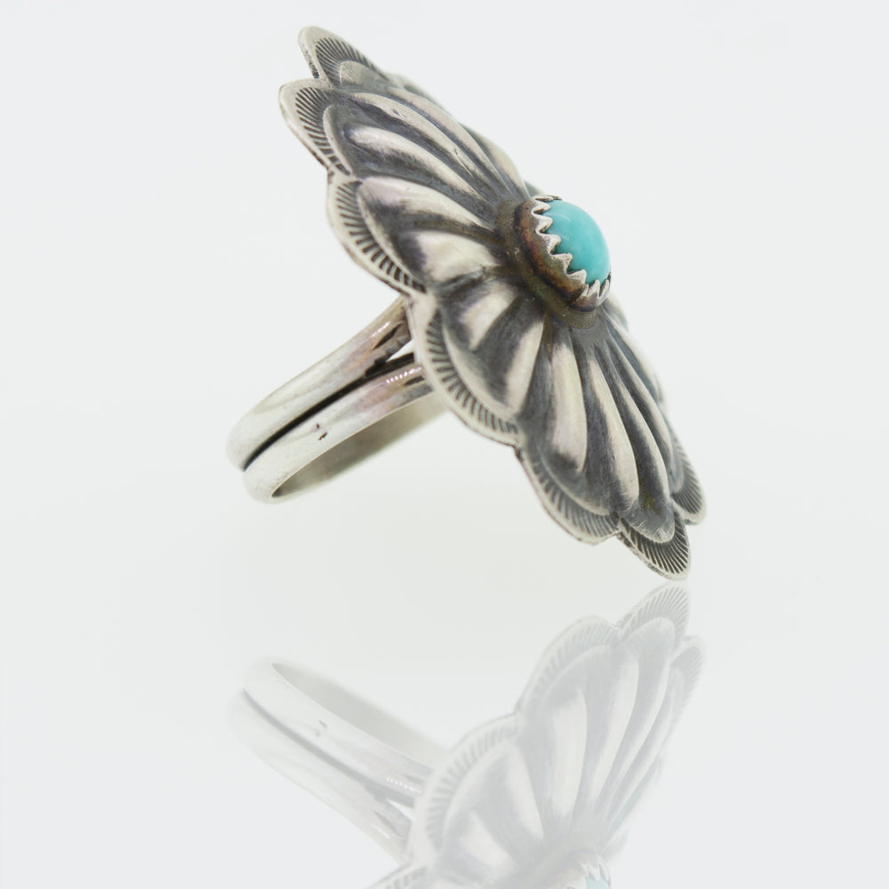 A Native American Turquoise Flower Ring with a turquoise stone.