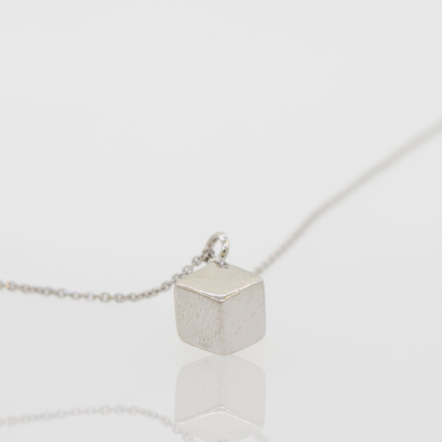 
                  
                    A Super Silver sleek three-dimensional silver cube necklace.
                  
                