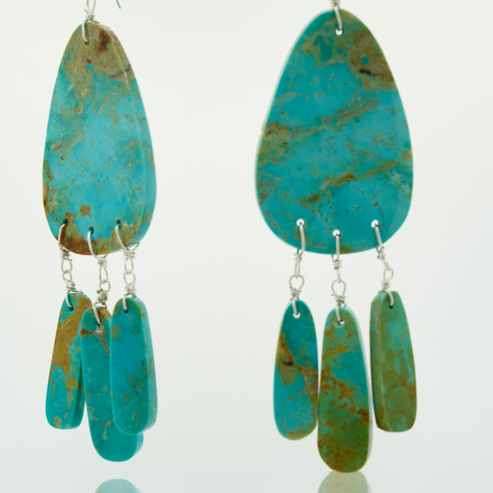 
                  
                    A pair of Super Silver Native American Raw Turquoise Earrings on a white background, showcasing Native American Jewelry.
                  
                