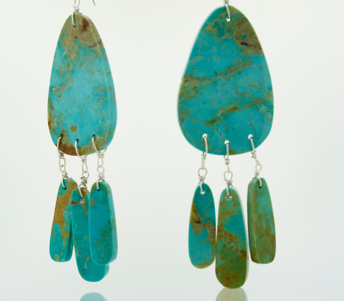 
                  
                    A pair of Super Silver Native American Raw Turquoise Earrings on a white background, showcasing Native American Jewelry.
                  
                