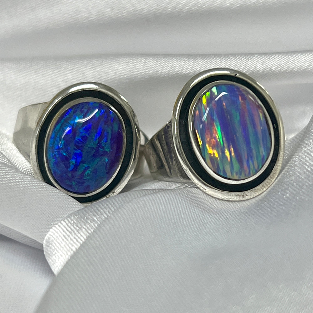 Two Radiant Opal Signet Rings on a white cloth.