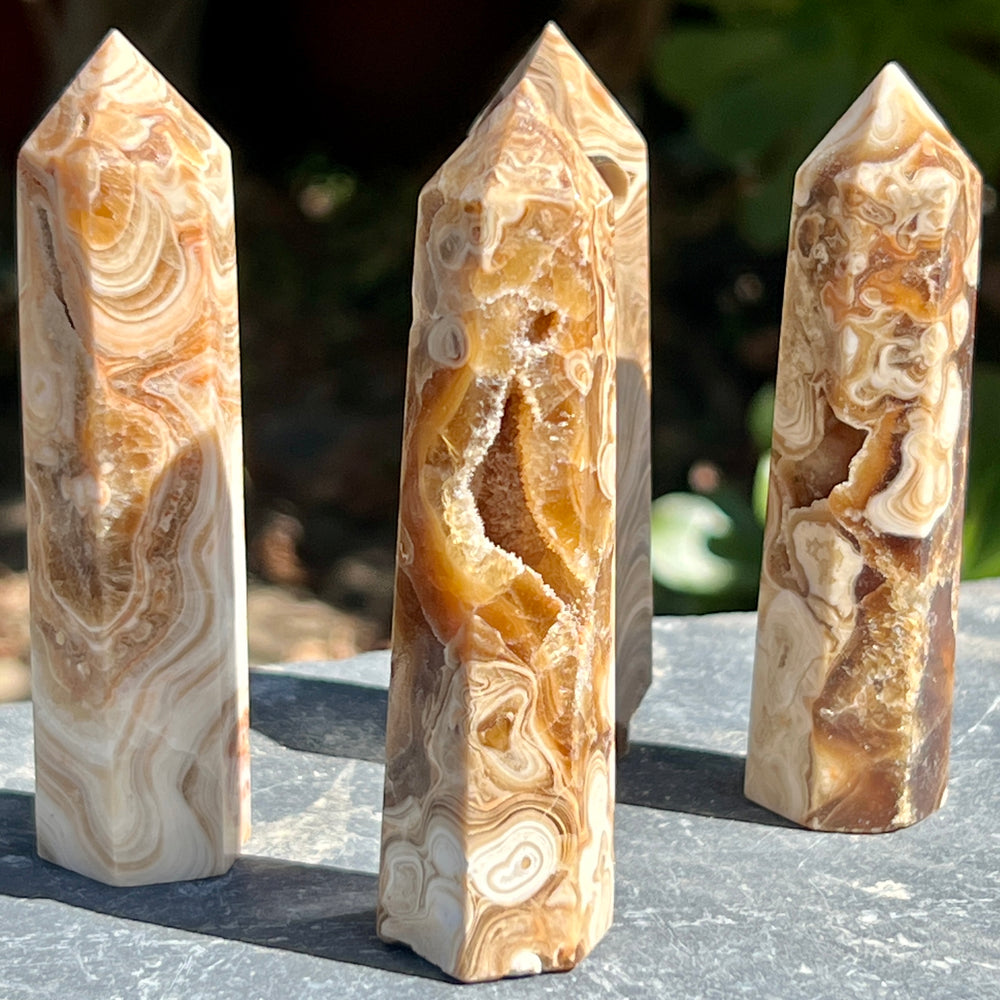
                  
                    Three pieces of brown aragonite obelisk sitting on top of a table, serving as decorative obelisks.
                  
                