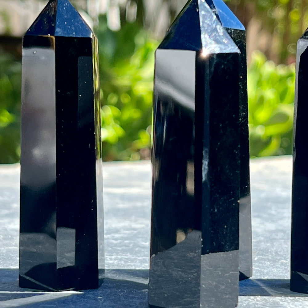 
                  
                    Three gothic Black Obsidian Obelisks sitting on a table.
                  
                