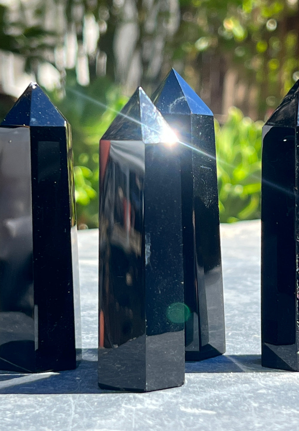 Three Black Obsidian Obelisks sitting on a table.