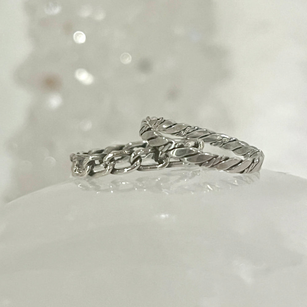 
                  
                    Two Dainty Twisted Rope Band Rings, with a rustic allure and vintage vibe, sitting on top of a piece of snow. (Super Silver)
                  
                