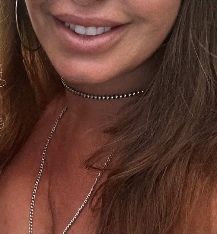A woman wearing an edgy Super Silver Handcrafted Navajo Pearl Choker.