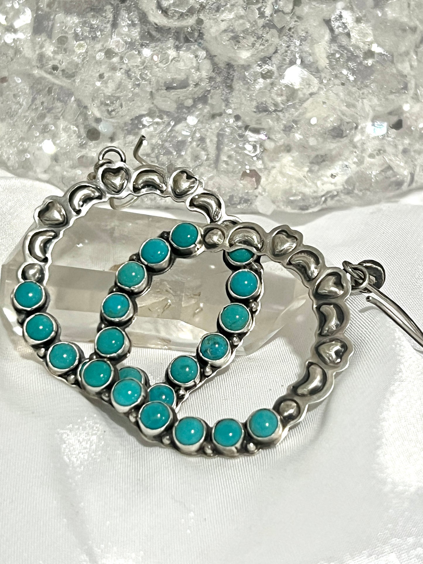 
                  
                    A pair of Super Silver Statement Handmade Turquoise Earrings with southwestern elegance displayed on a table.
                  
                
