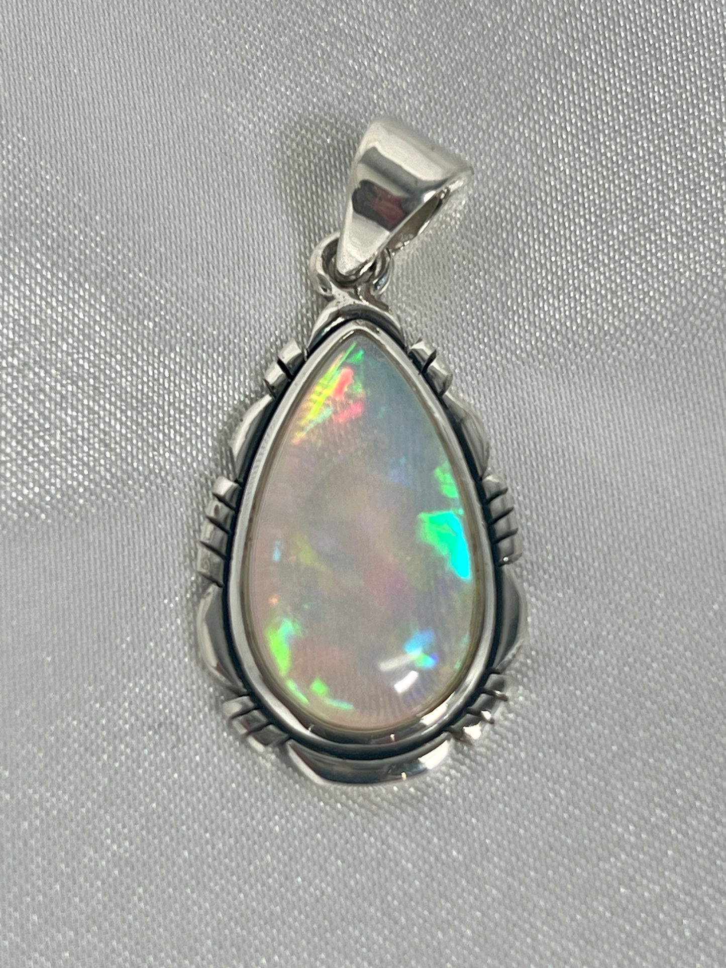 
                  
                    A Super Silver statement pendant featuring a brilliant Ethiopian Opal Teardrop Shaped Pendant with Detailed Setting, set in sterling silver.
                  
                