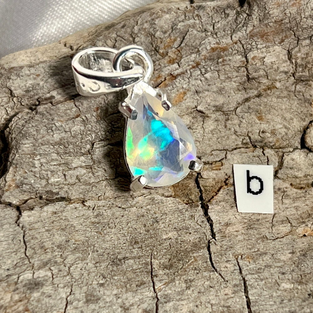
                  
                    A Dainty Prong Set Facet Cut Teardrop Shaped Ethiopian Opal Pendant with the letter b on it, crafted in Sterling Silver by Super Silver.
                  
                