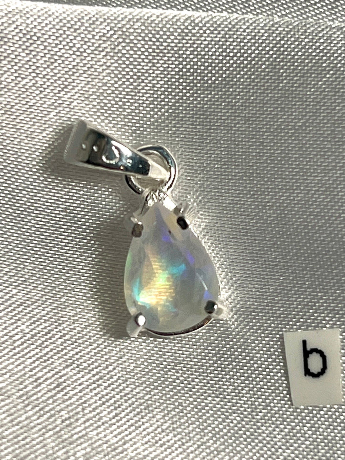 
                  
                    A Dainty Prong Set Facet Cut Teardrop Shaped Ethiopian Opal Pendant made of sterling silver by Super Silver.
                  
                