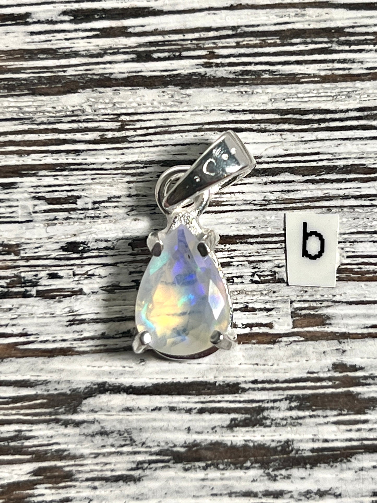 
                  
                    A Super Silver Dainty Prong Set Facet Cut Teardrop Shaped Ethiopian Opal Pendant with the letter b.
                  
                