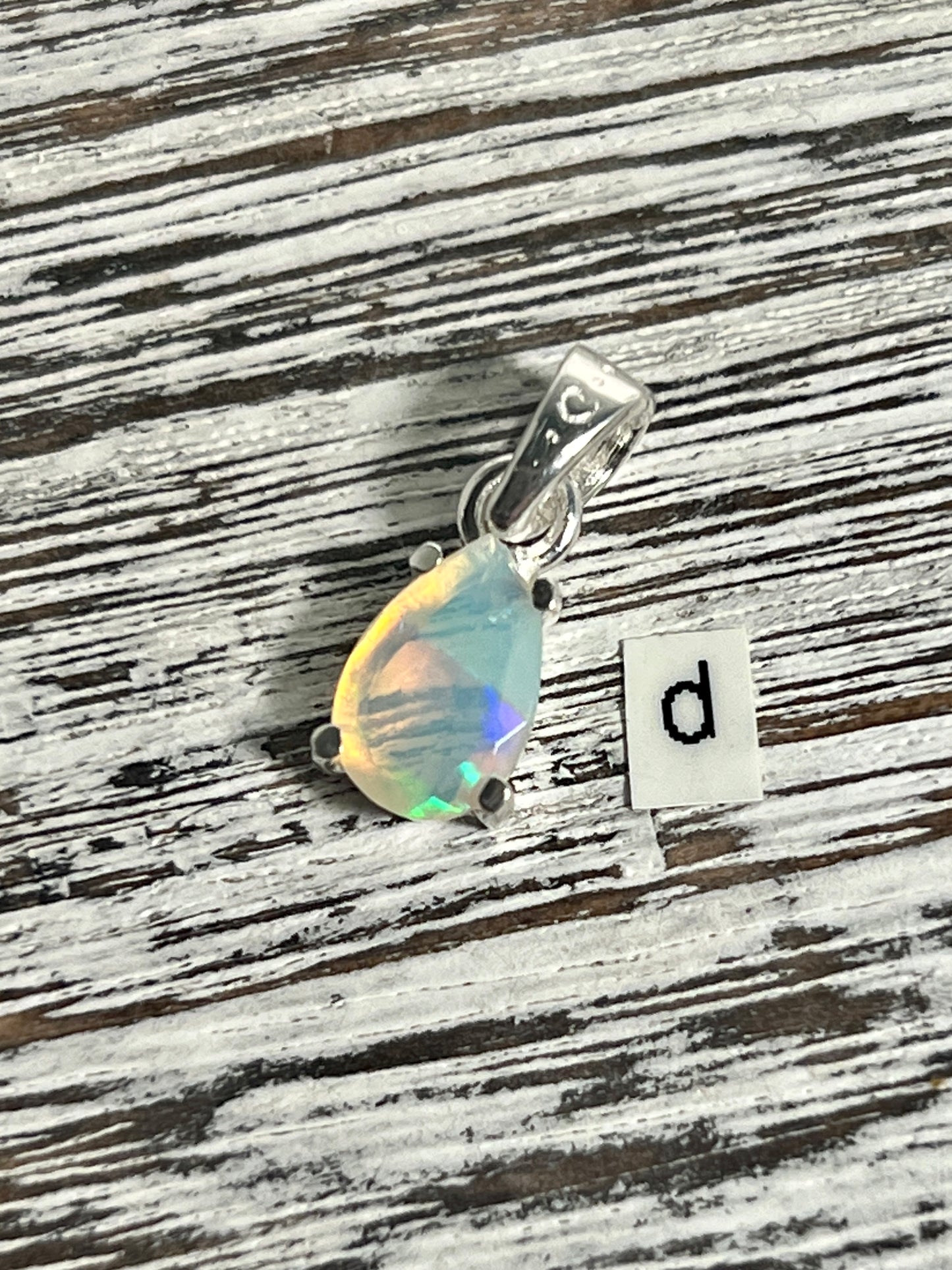 
                  
                    A Super Silver Dainty Prong Set Facet Cut Teardrop Shaped Ethiopian Opal Pendant adorned with a captivating Ethiopian opal and elegantly engraved with the letter d.
                  
                