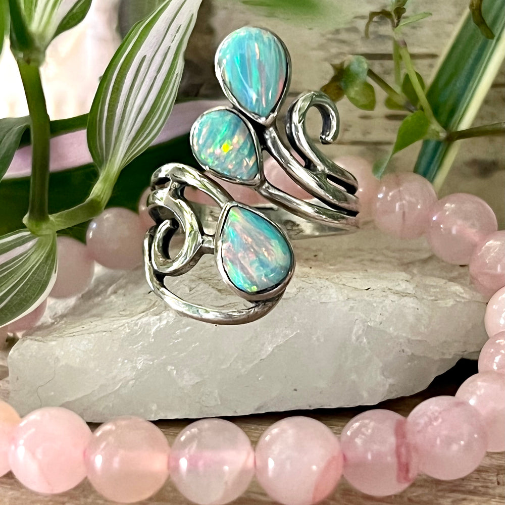 
                  
                    Super Silver's Stunning Wrap-Around Opal Ring, featuring opal stone and pink beads atop a rock.
                  
                