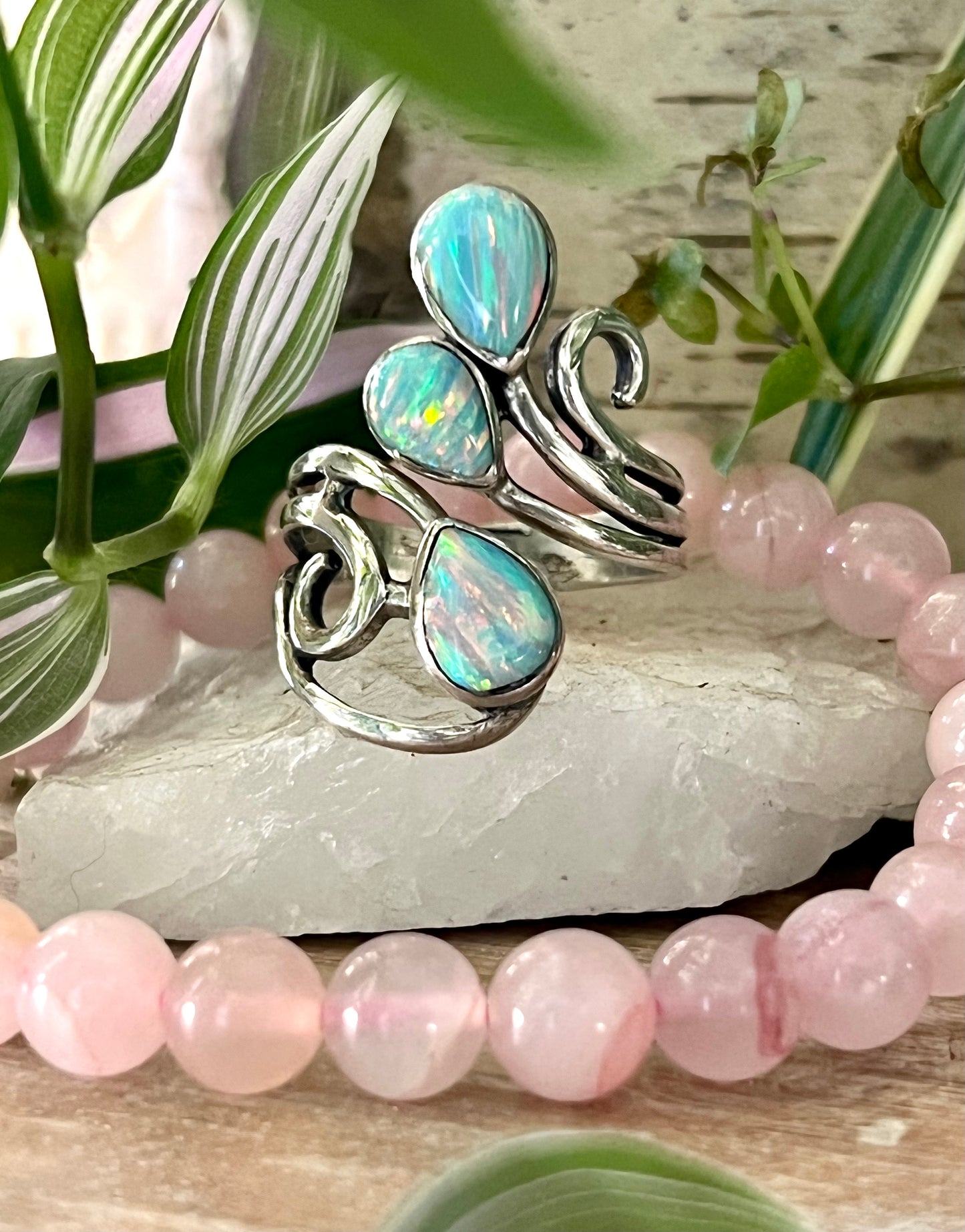 
                  
                    Super Silver's Stunning Wrap-Around Opal Ring, featuring opal stone and pink beads atop a rock.
                  
                