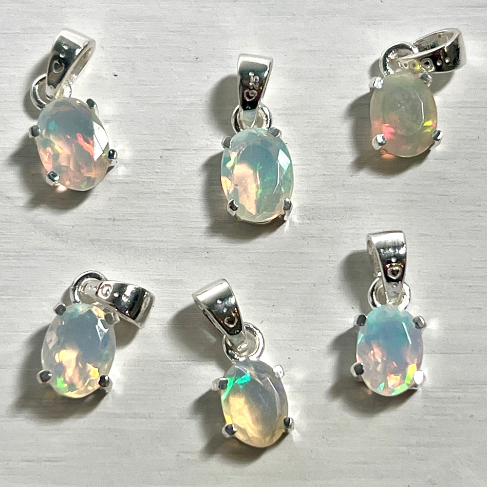 
                  
                    Six Tiny Facet Cut Prong Set Ethiopian Opal Pendants with Super Silver on a white surface.
                  
                
