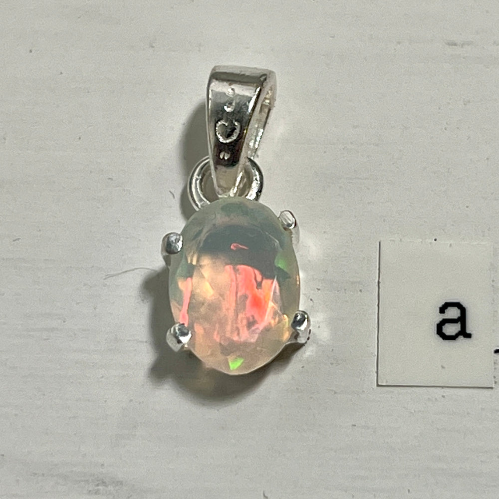 
                  
                    A dainty Super Silver Tiny Facet Cut Prong Set Ethiopian Opal Pendant with the letter a on it.
                  
                