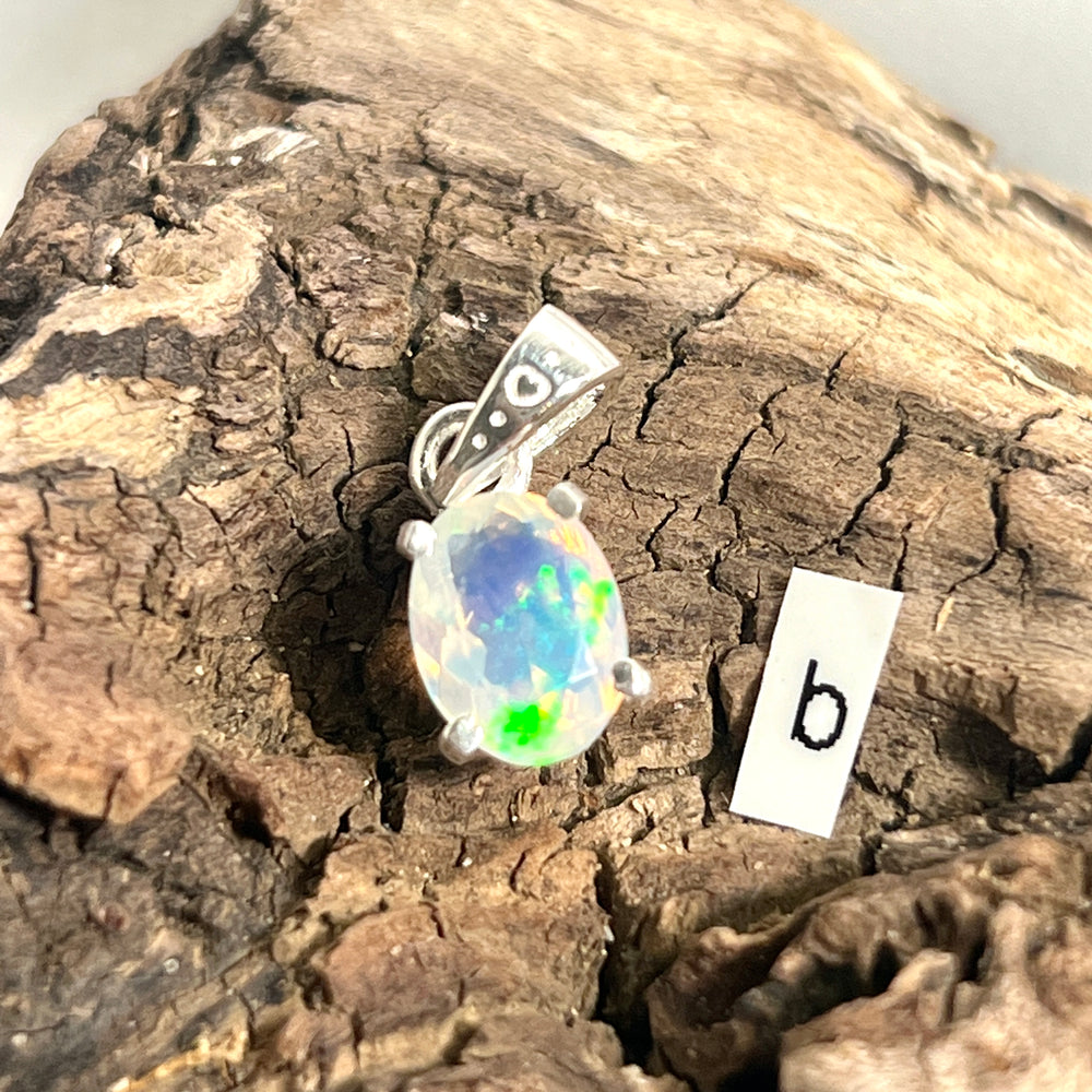 
                  
                    A dainty Super Silver Tiny Facet Cut Prong Set Ethiopian Opal Pendant with the letter b on it.
                  
                