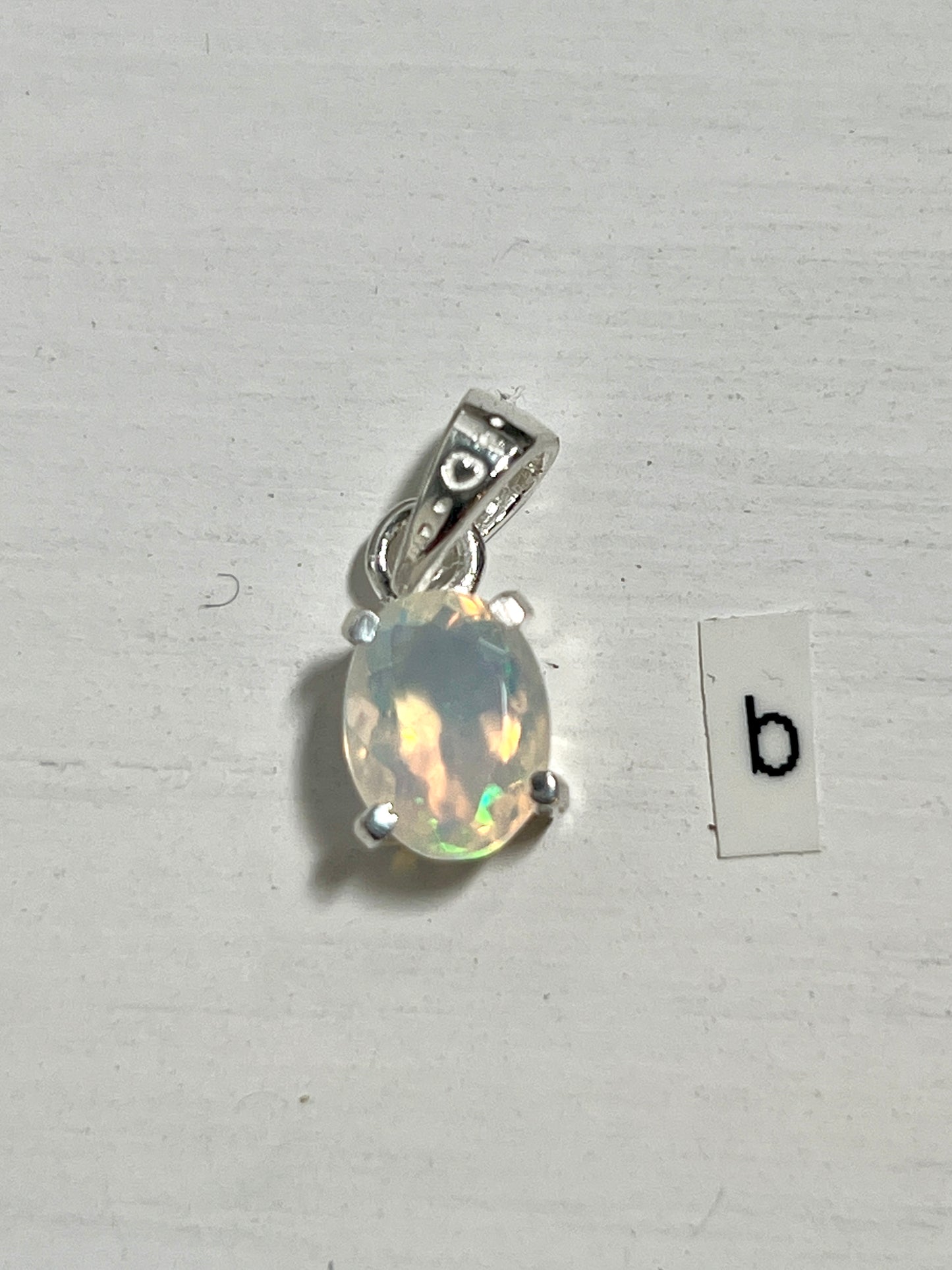 
                  
                    A Tiny Facet Cut Prong Set Ethiopian Opal Pendant with the letter b on it made of ethiopian opal - made by Super Silver.
                  
                
