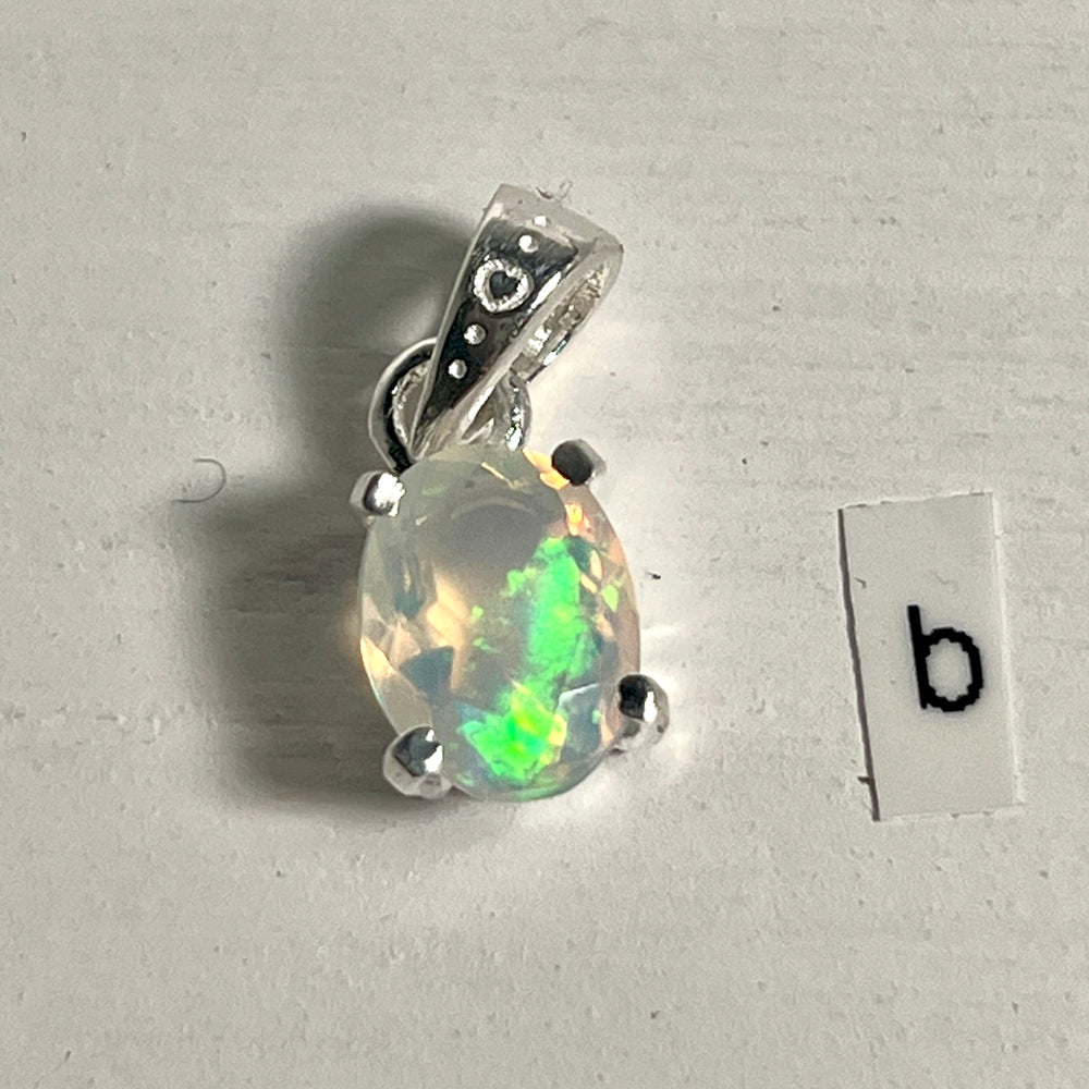 
                  
                    A Tiny Facet Cut Prong Set Ethiopian Opal Pendant by Super Silver with the letter B intricately engraved on it.
                  
                