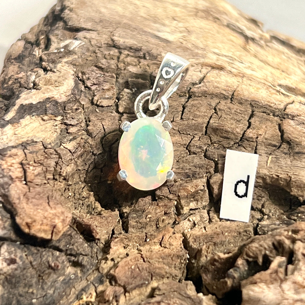 
                  
                    A dainty Super Silver Tiny Facet Cut Prong Set Ethiopian Opal Pendant with the letter D intricately engraved on it.
                  
                