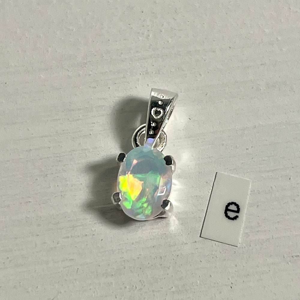 
                  
                    A dainty Tiny Facet Cut Prong Set Ethiopian Opal Pendant with the letter e, crafted in .925 sterling silver from Super Silver.
                  
                