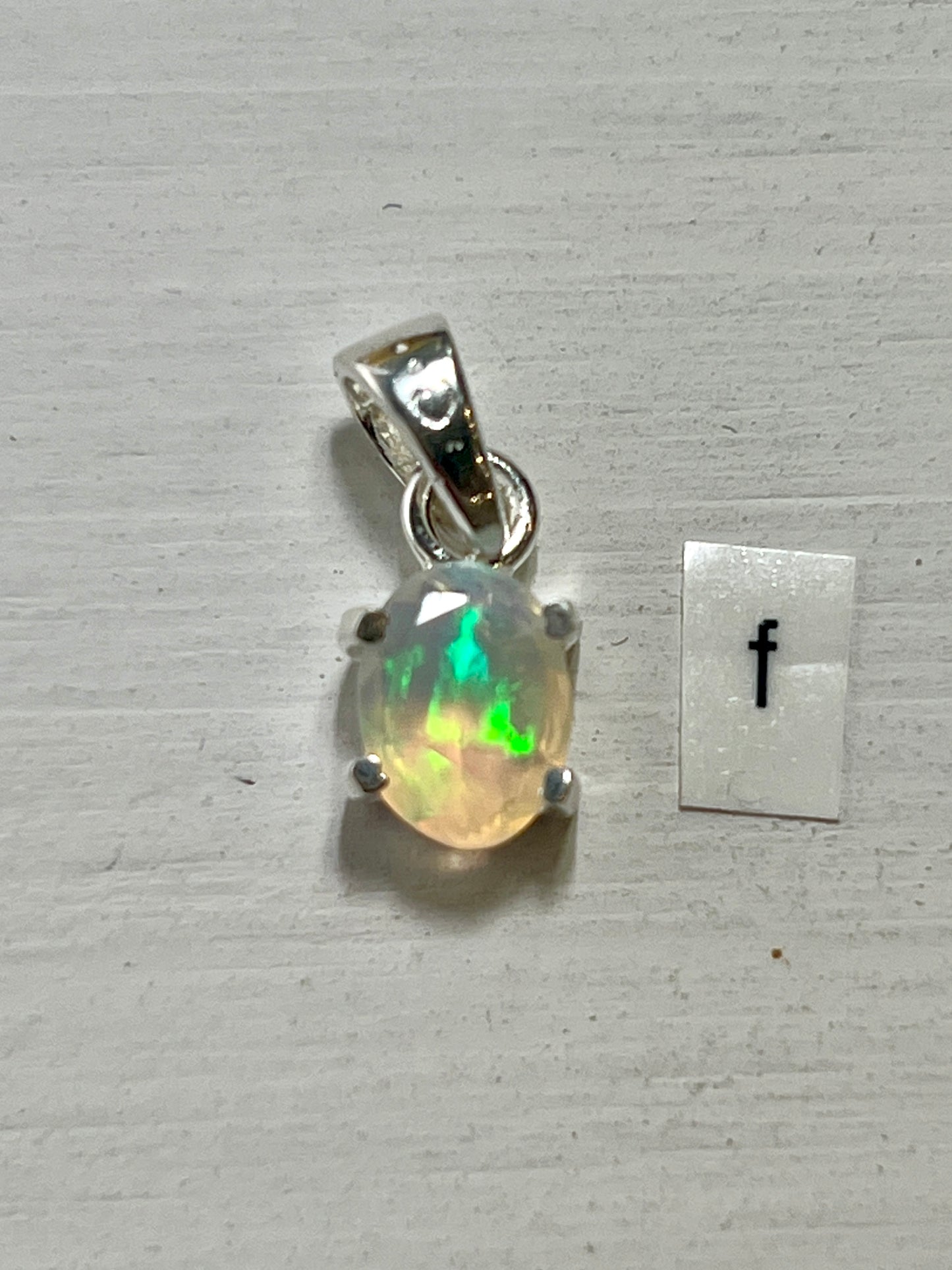 
                  
                    A Super Silver Tiny Facet Cut Prong Set Ethiopian Opal Pendant featuring a delicate Ethiopian opal in vibrant green.
                  
                