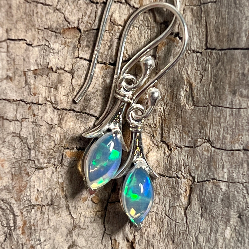 
                  
                    A pair of Modern Marquise Shaped Ethiopian Opal earrings by Super Silver on a piece of wood.
                  
                