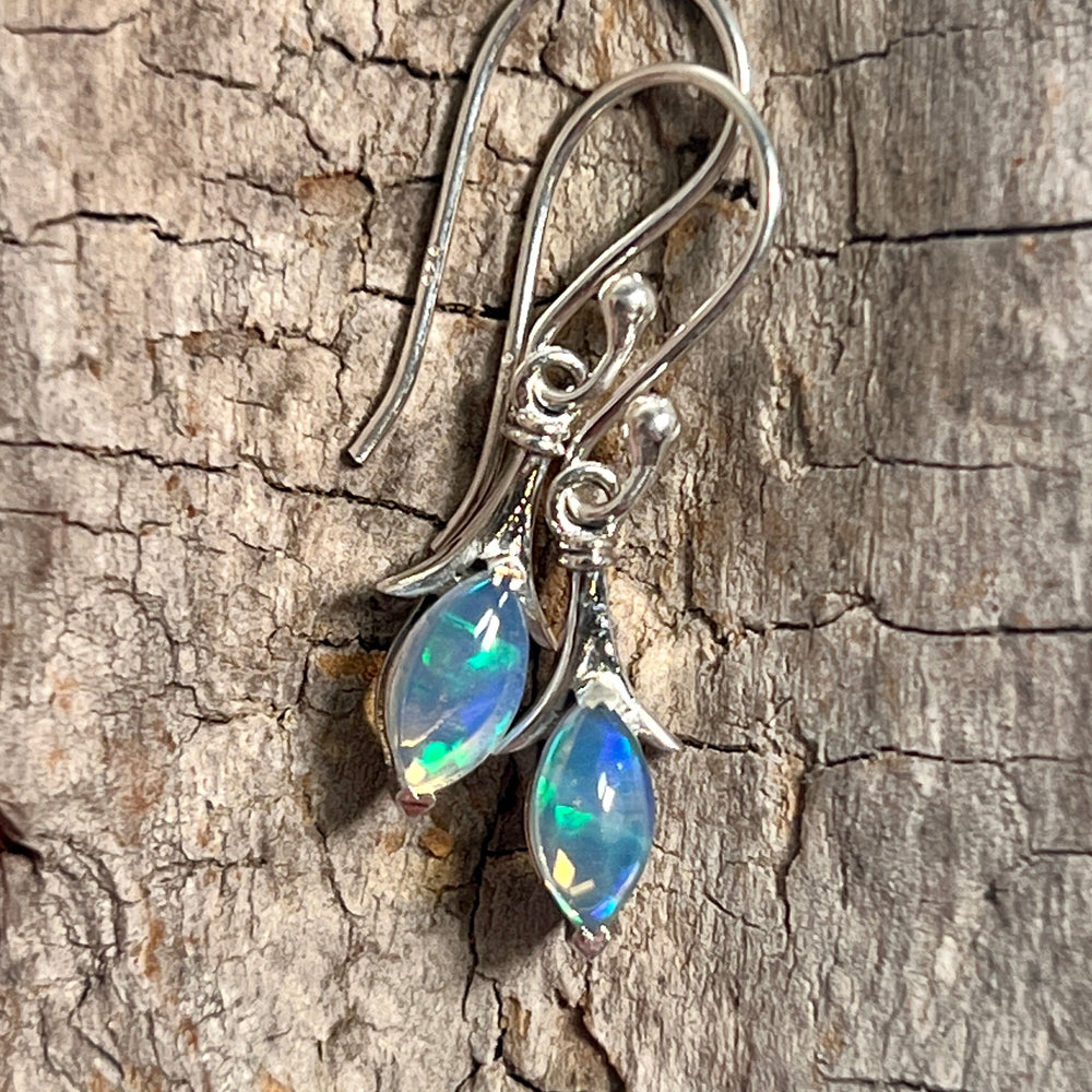 
                  
                    A pair of Modern Marquise Shaped Ethiopian Opal Earrings by Super Silver on a piece of wood.
                  
                