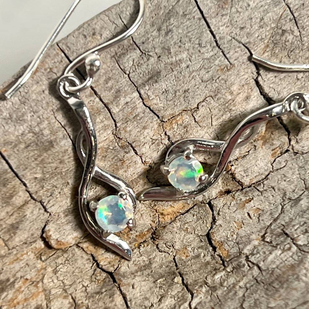 
                  
                    A pair of Super Silver Modern Ethiopian Opal earrings on a piece of wood.
                  
                
