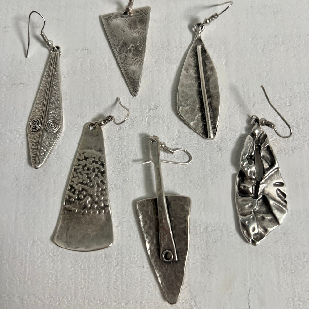 A collection of Super Silver's Triangular Boho Statement Earrings, made of Zamak, arranged elegantly on a pristine white surface.