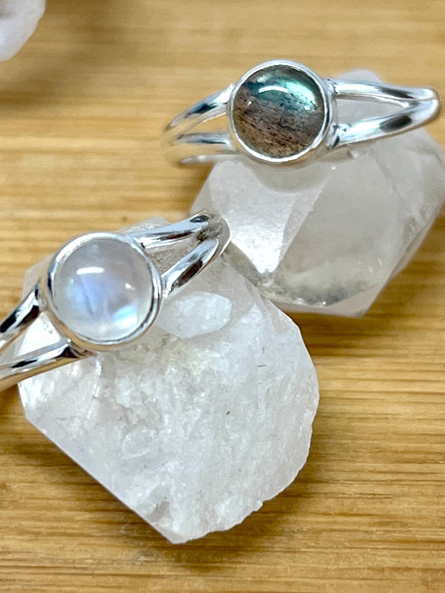 Two Circular Minimalist Stone Rings by Super Silver on top of a rock.