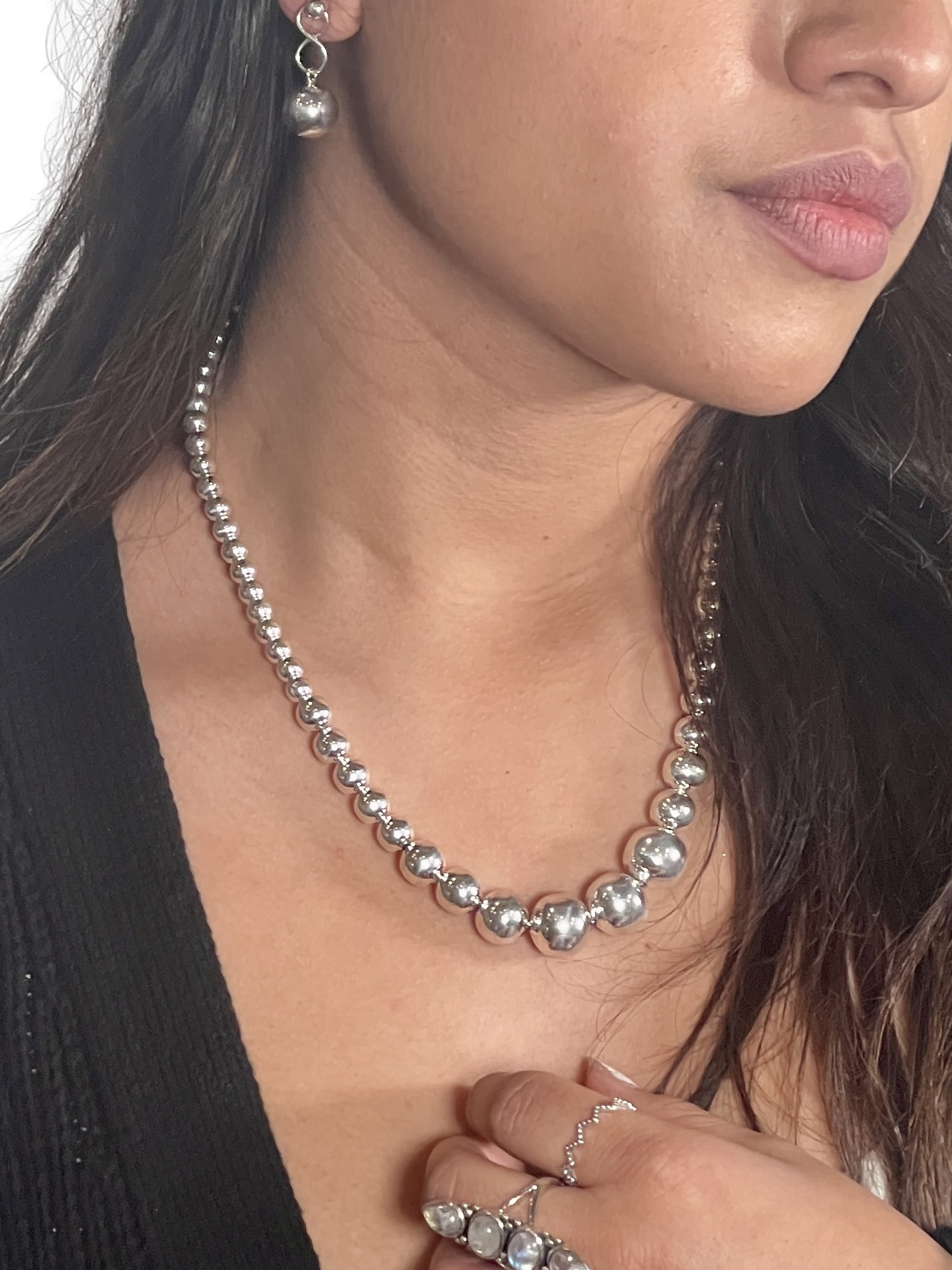 
                  
                    A woman wearing a Super Silver Graduated Silver Bead Necklace and silver earrings.
                  
                