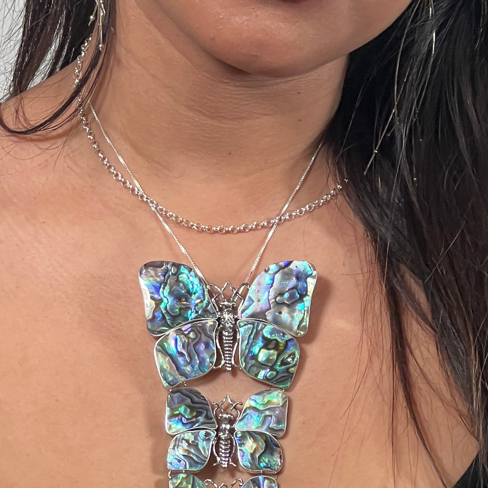 
                  
                    A nature lover adorned with a Super Silver statement pendant necklace/brooch with three butterflies.
                  
                