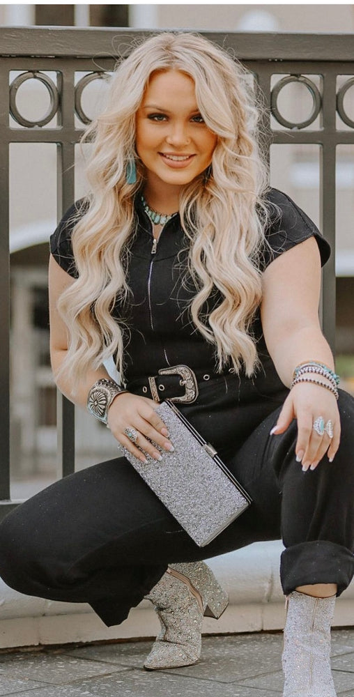 
                  
                    A blonde woman, wearing a black jumpsuit, poses for a photo with a Super Silver Hand Crafted Silver Concho Cuff accessory, incorporating Native American and southwest influences.
                  
                