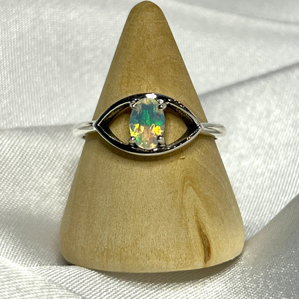 An elegant Facet Cut Ethiopian Opal Evil Eye Ring on a white background.