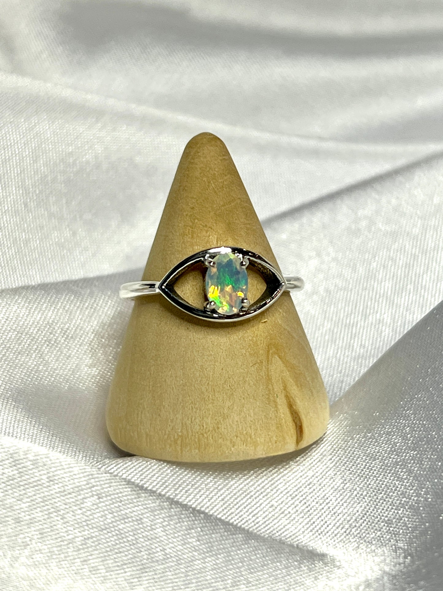 
                  
                    An elegant Facet Cut Ethiopian Opal Evil Eye Ring on a white background.
                  
                