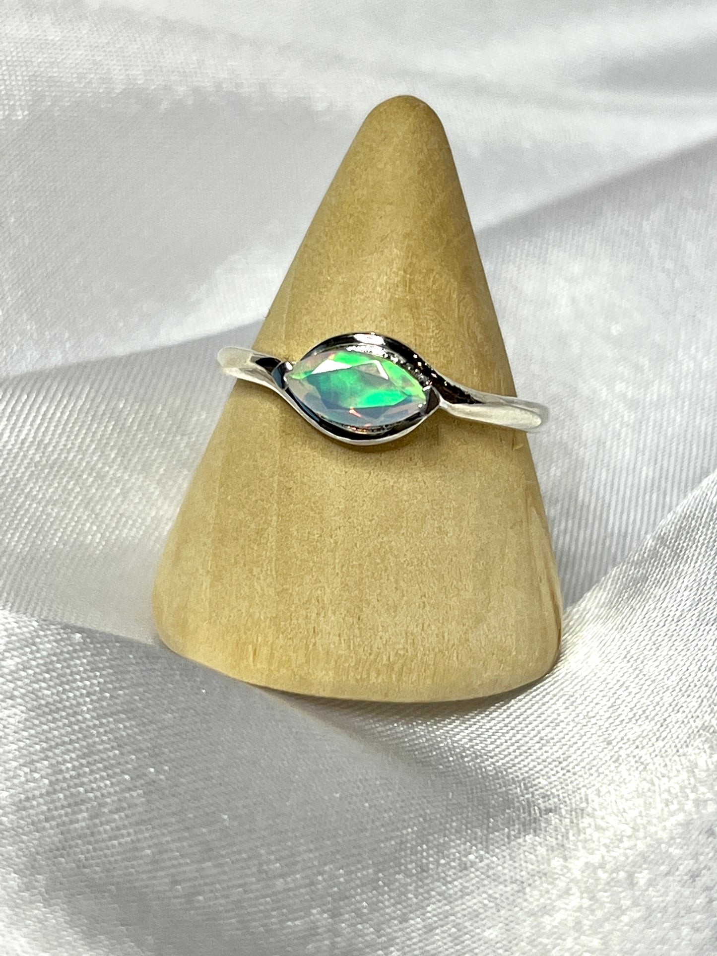 An elegant Brilliant Facet Cut Ethiopian Opal Ring featuring a stunning Ethiopian opal stone on top.