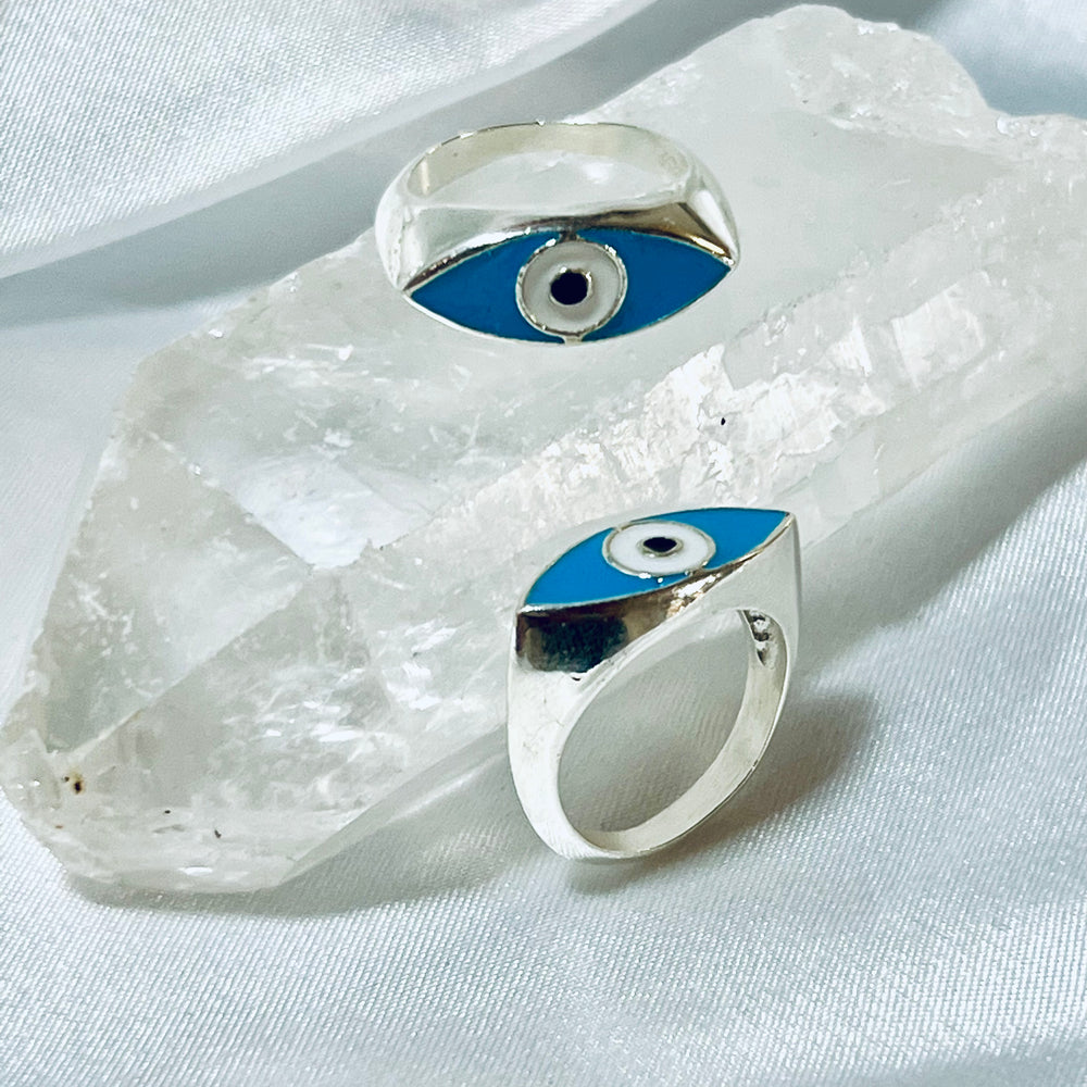 Two Super Silver Evil Eye Rings on top of a crystal.