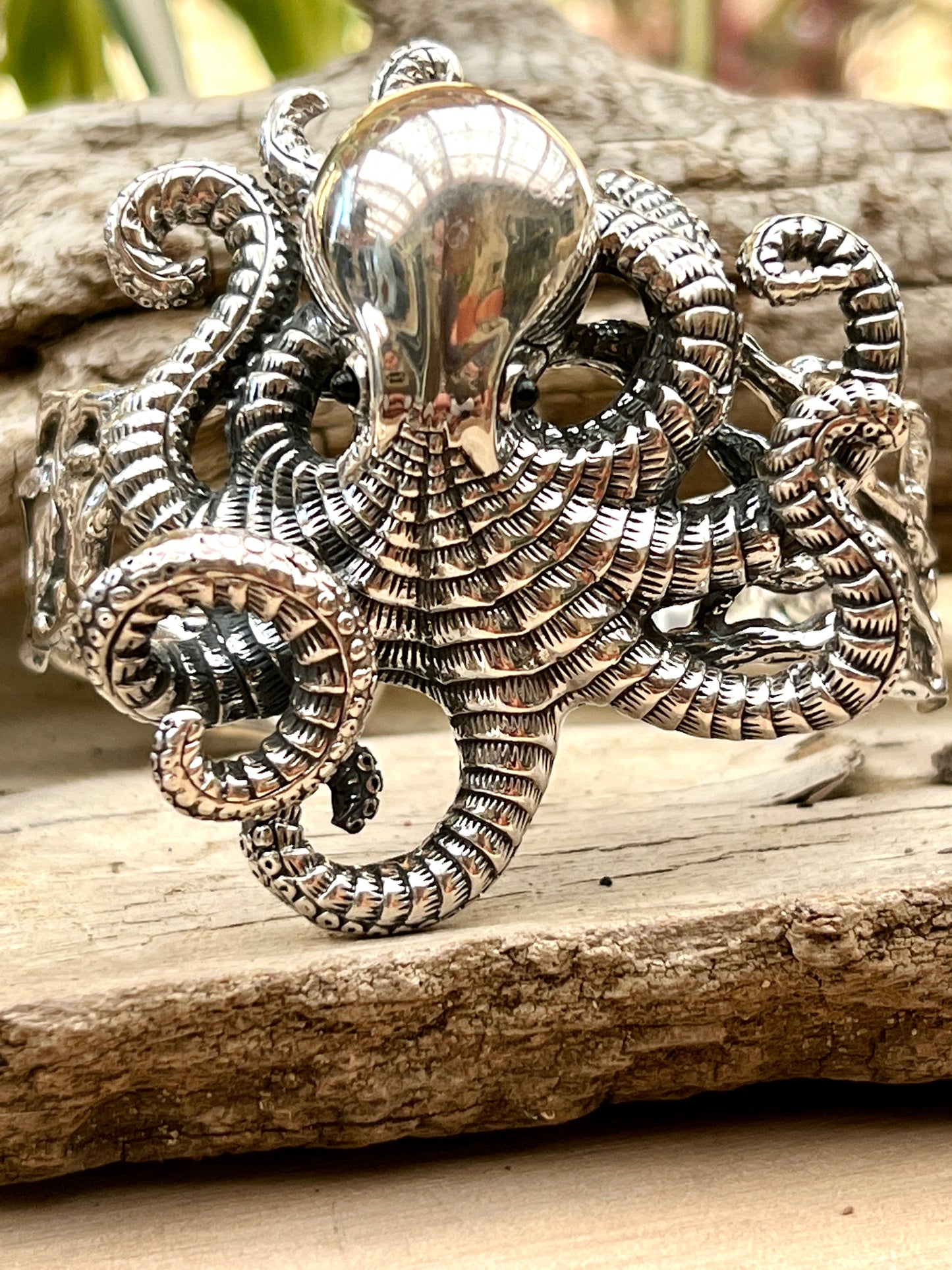 
                  
                    A Super Silver Octopus Statement Bracelet adorned on a piece of wood.
                  
                