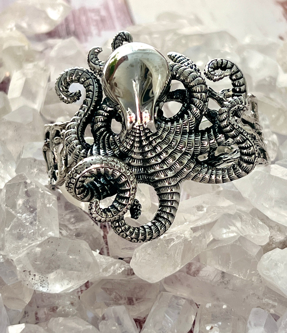 A Super Silver Octopus Statement Bracelet elegantly resting on top of shimmering crystals.