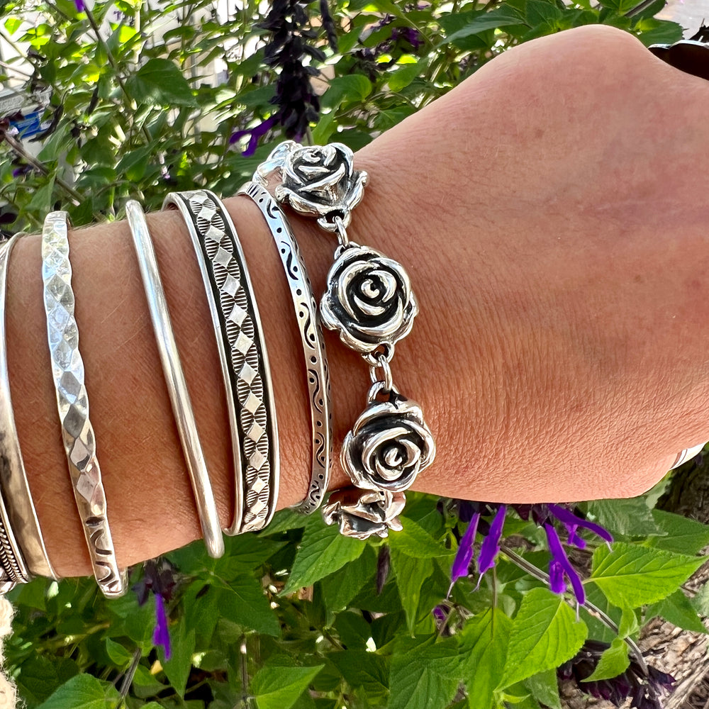 
                  
                    A woman's hand is showcasing a statement piece - the Chic Link Rose Bracelet, created through the electroformed process by Super Silver.
                  
                