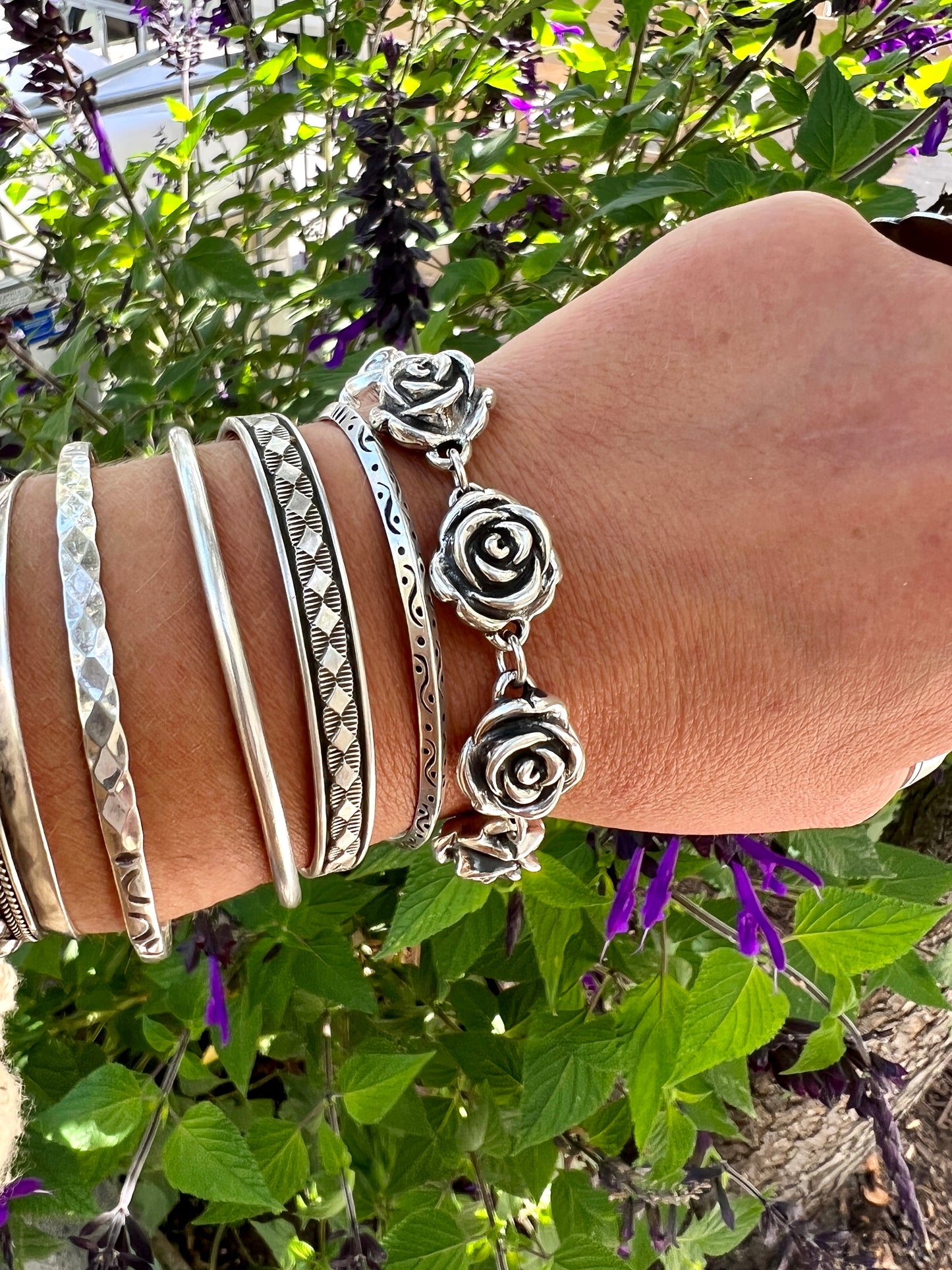
                  
                    A woman's hand is showcasing a statement piece - the Chic Link Rose Bracelet, created through the electroformed process by Super Silver.
                  
                